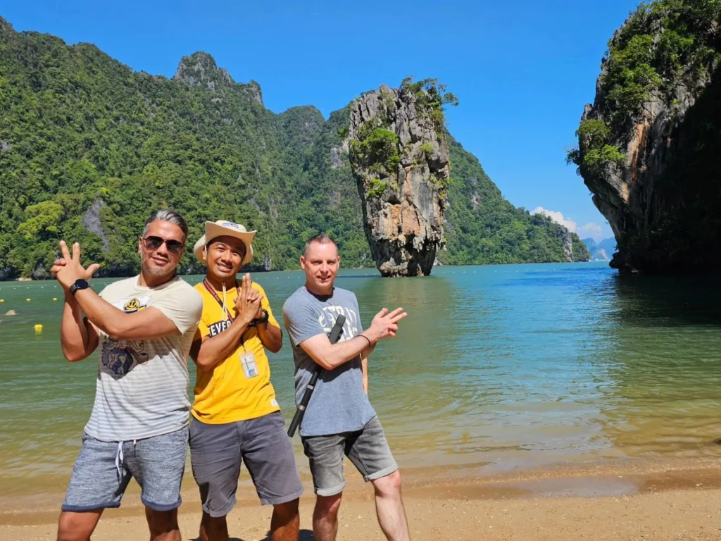 Cruising with Danny and Peter, Holland America Line, Westerdam, Phuket, Thailand | Longtail boat navigating clear waters near James Bond Island, showcasing iconic limestone cliffs. Enjoy dining at a floating restaurant on Phang Nga Bay, kayaking through lush mangroves, and exploring hidden caves with unique rock formations during an unforgettable Phuket island tour.