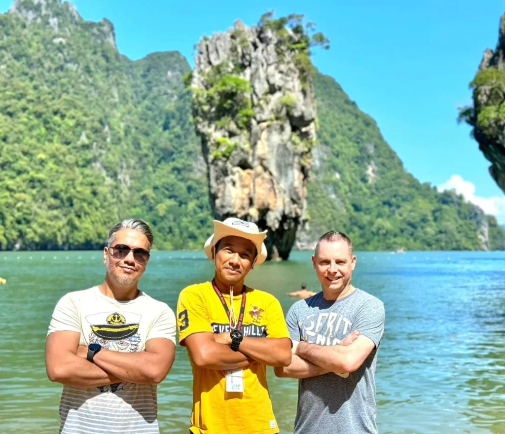 Cruising with Danny and Peter, Holland America Line, Westerdam, Phuket, Thailand | Longtail boat navigating clear waters near James Bond Island, showcasing iconic limestone cliffs. Enjoy dining at a floating restaurant on Phang Nga Bay, kayaking through lush mangroves, and exploring hidden caves with unique rock formations during an unforgettable Phuket island tour.