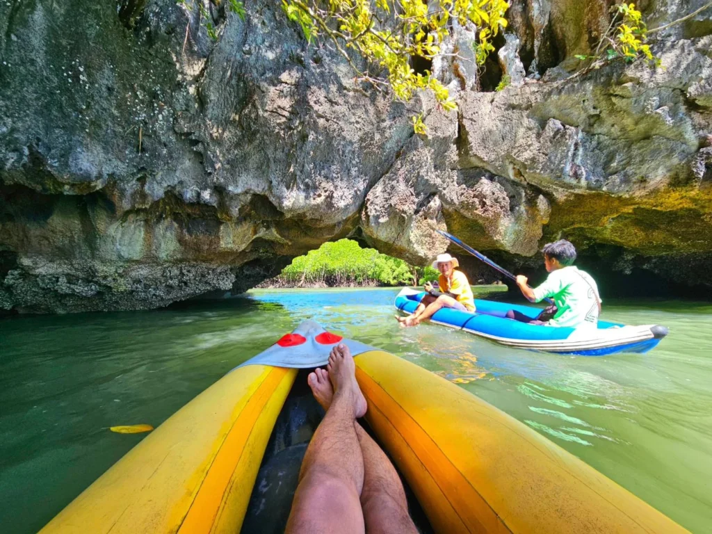 Cruising with Danny and Peter, Holland America Line, Westerdam, Phuket, Thailand | Longtail boat navigating clear waters near James Bond Island, showcasing iconic limestone cliffs. Enjoy dining at a floating restaurant on Phang Nga Bay, kayaking through lush mangroves, and exploring hidden caves with unique rock formations during an unforgettable Phuket island tour.