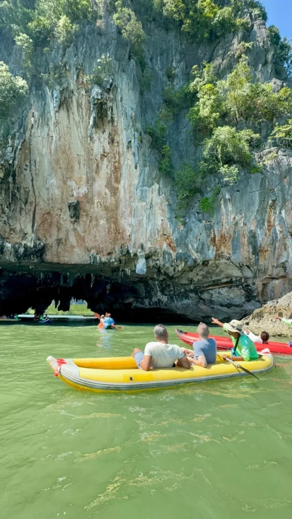 Cruising with Danny and Peter, Holland America Line, Westerdam, Phuket, Thailand | Longtail boat navigating clear waters near James Bond Island, showcasing iconic limestone cliffs. Enjoy dining at a floating restaurant on Phang Nga Bay, kayaking through lush mangroves, and exploring hidden caves with unique rock formations during an unforgettable Phuket island tour.