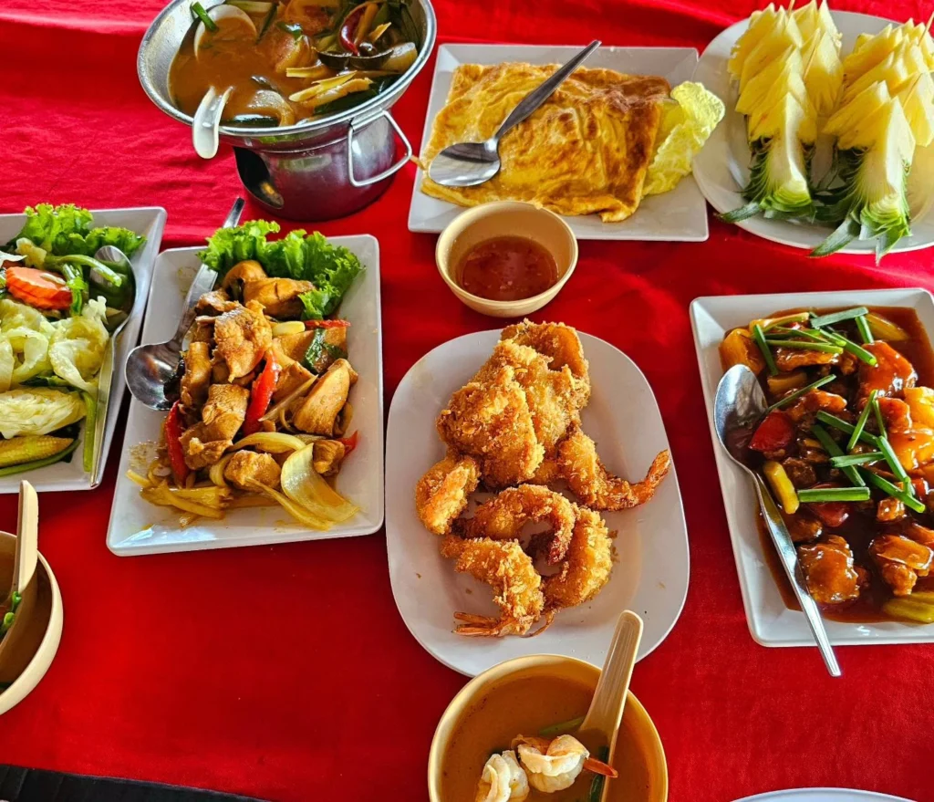 Cruising with Danny and Peter, Holland America Line, Westerdam, Phuket, Thailand | Longtail boat navigating clear waters near James Bond Island, showcasing iconic limestone cliffs. Enjoy dining at a floating restaurant on Phang Nga Bay, kayaking through lush mangroves, and exploring hidden caves with unique rock formations during an unforgettable Phuket island tour.