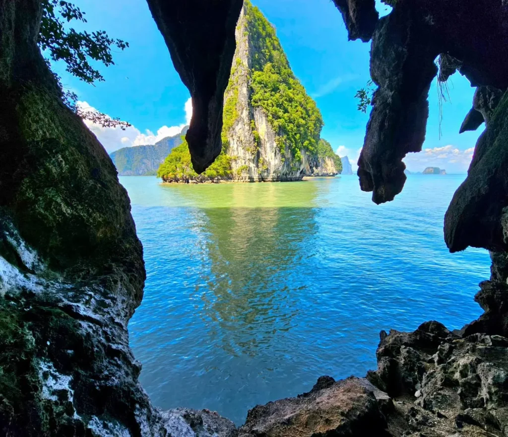 Cruising with Danny and Peter, Holland America Line, Westerdam, Phuket, Thailand | Longtail boat navigating clear waters near James Bond Island, showcasing iconic limestone cliffs. Enjoy dining at a floating restaurant on Phang Nga Bay, kayaking through lush mangroves, and exploring hidden caves with unique rock formations during an unforgettable Phuket island tour.
