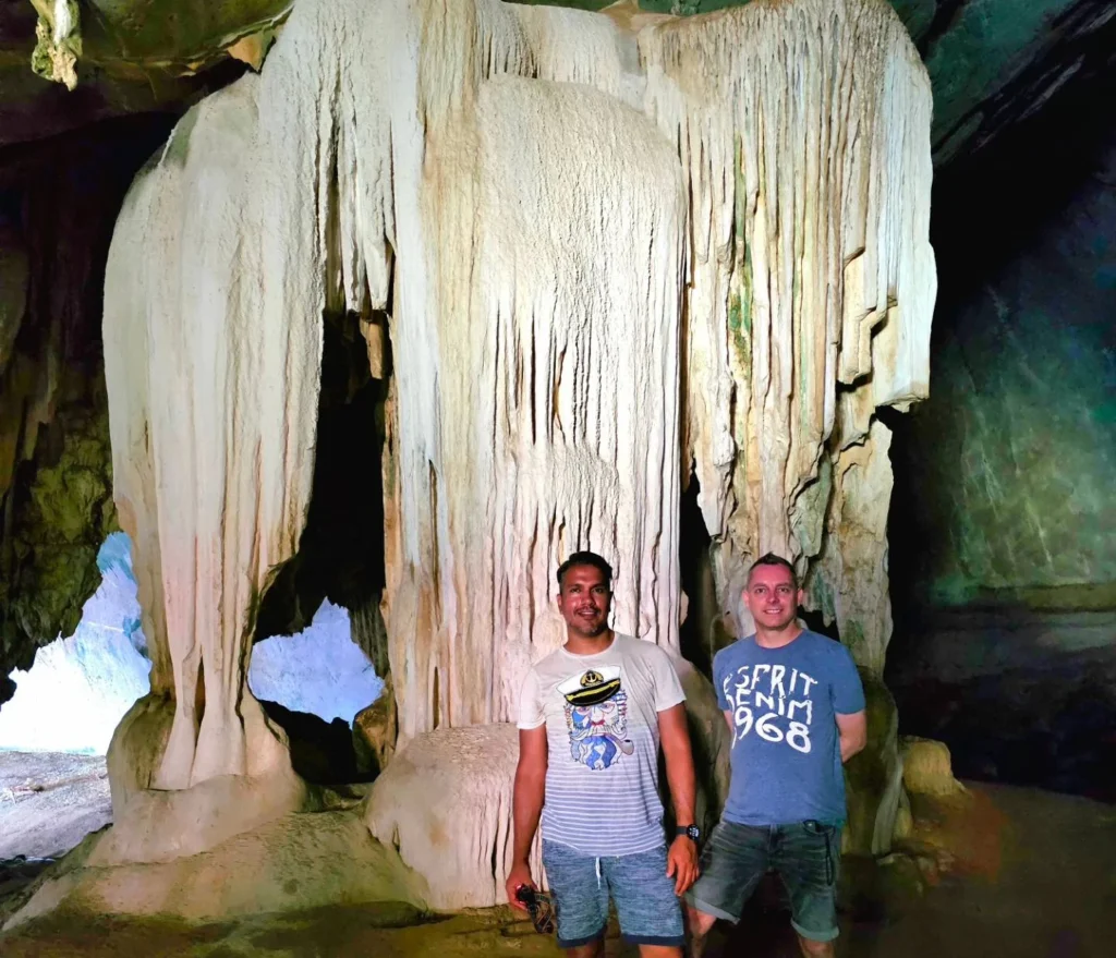 Cruising with Danny and Peter, Holland America Line, Westerdam, Phuket, Thailand | Longtail boat navigating clear waters near James Bond Island, showcasing iconic limestone cliffs. Enjoy dining at a floating restaurant on Phang Nga Bay, kayaking through lush mangroves, and exploring hidden caves with unique rock formations during an unforgettable Phuket island tour.