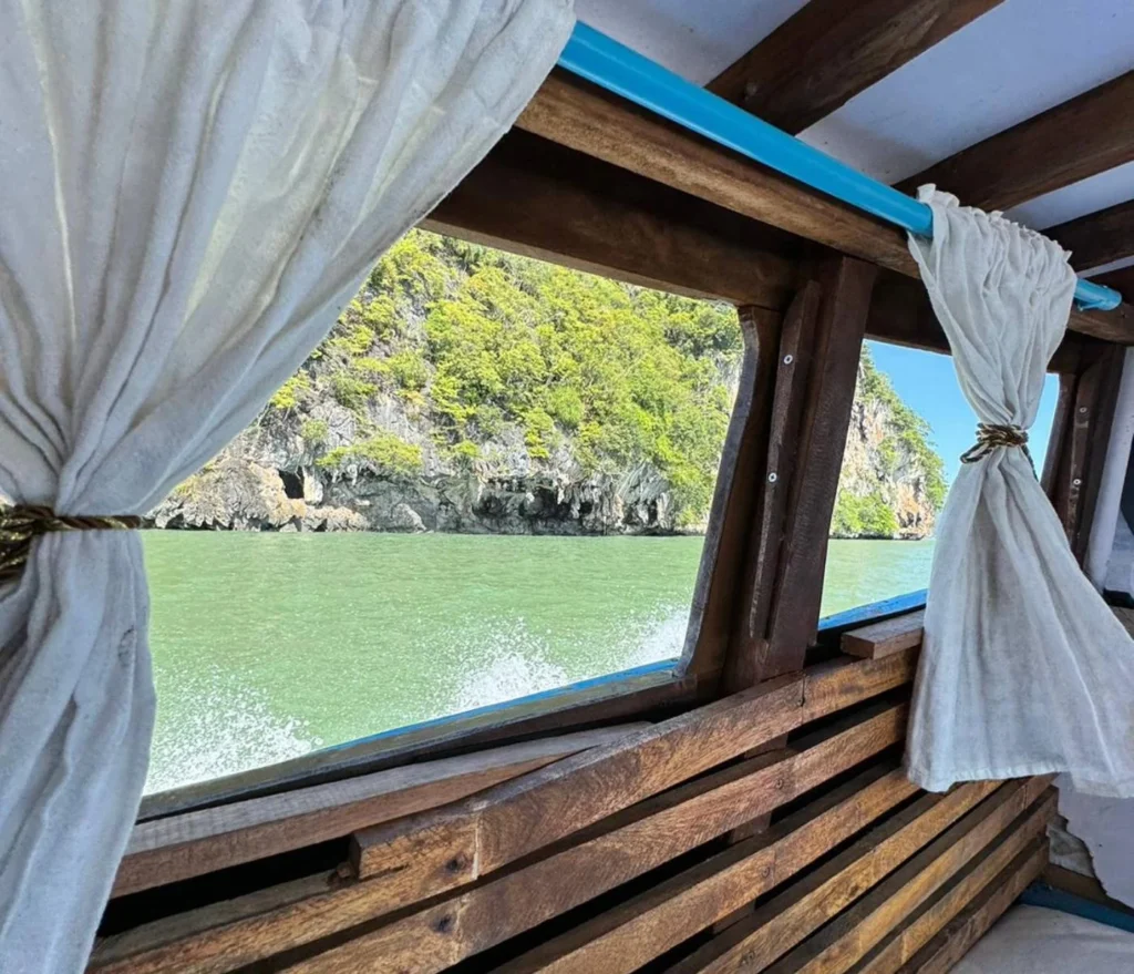 Cruising with Danny and Peter, Holland America Line, Westerdam, Phuket, Thailand | Longtail boat navigating clear waters near James Bond Island, showcasing iconic limestone cliffs. Enjoy dining at a floating restaurant on Phang Nga Bay, kayaking through lush mangroves, and exploring hidden caves with unique rock formations during an unforgettable Phuket island tour.