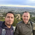 Cruising with Danny and Peter, Holland America Line, Koningsdam, Los Angeles, California, United States | A stunning panoramic view from the Hollywood Hills walk, showcasing the sprawling city of Los Angeles below, vibrant greenery along the hiking trails, and friends enjoying an inspiring nature walk in this iconic landscape.