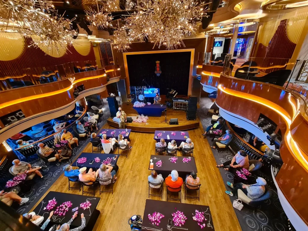 Cruising with Danny and Peter, Holland America Line, Koningsdam, Pacific Ocean, Sea Day | Guests enjoying a Hawaiian cruise experience, participating in cultural activities at sea, including lei-making, ukulele workshops, and hula dance lessons, surrounded by the beauty of the ocean and the spirit of Aloha.