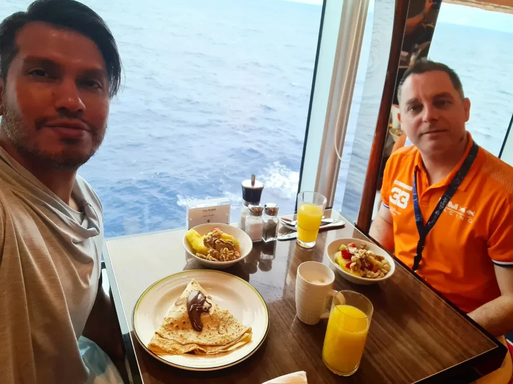 Cruising with Danny and Peter, Holland America Line, Koningsdam, Pacific Ocean, Sea Day | Passengers enjoying a tranquil Holland America sea day aboard a luxury cruise ship, participating in ocean voyage activities such as ukulele lessons, savoring gourmet dining at sea, and relaxing by the pool while overlooking the serene waters. The elegant ship provides panoramic ocean views and a perfect setting for a memorable Holland America Line experience. The day also includes presentations on maritime history, reflecting the ultimate luxury travel experience at sea.