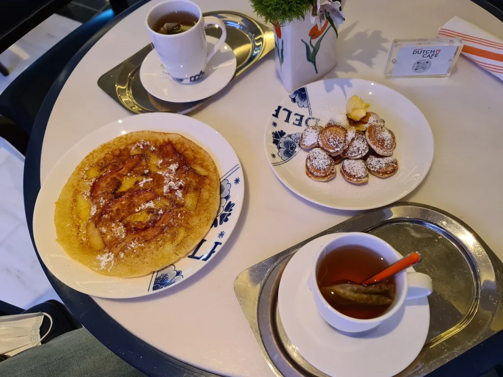 Cruising with Danny and Peter, Holland America Line, Koningsdam, Pacific Ocean, Sea Day | Passengers enjoying a tranquil Holland America sea day aboard a luxury cruise ship, participating in ocean voyage activities such as ukulele lessons, savoring gourmet dining at sea, and relaxing by the pool while overlooking the serene waters. The elegant ship provides panoramic ocean views and a perfect setting for a memorable Holland America Line experience. The day also includes presentations on maritime history, reflecting the ultimate luxury travel experience at sea.