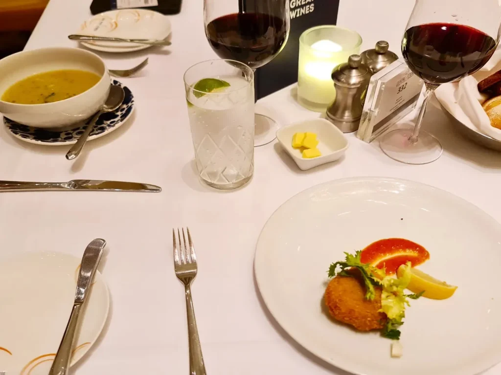 Cruising with Danny and Peter, Holland America Line, Koningsdam, Pacific Ocean, Sea Day | Passengers enjoying a tranquil Holland America sea day aboard a luxury cruise ship, participating in ocean voyage activities such as ukulele lessons, savoring gourmet dining at sea, and relaxing by the pool while overlooking the serene waters. The elegant ship provides panoramic ocean views and a perfect setting for a memorable Holland America Line experience. The day also includes presentations on maritime history, reflecting the ultimate luxury travel experience at sea.