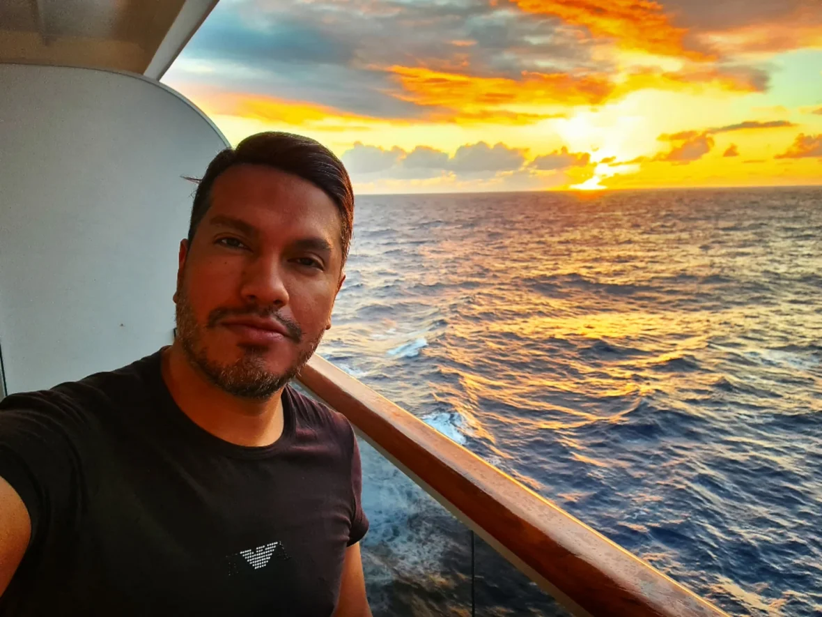 Cruising with Danny and Peter, Holland America Line, Koningsdam, Pacific Ocean, Sea Day | A stunning sunrise over the ocean during a Hawaiian cruise, showcasing the vibrant colors of the sky, a luxury cruise ship on calm waters, guests enjoying marine biology lectures, participating in ukulele lessons, and savoring delicious culinary experiences, embodying relaxation and adventure at sea in the beautiful Hawaiian Islands.