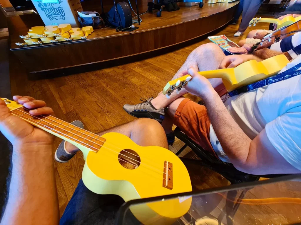 Cruising with Danny and Peter, Holland America Line, Koningsdam, Pacific Ocean, Sea Day | A stunning sunrise over the ocean during a Hawaiian cruise, showcasing the vibrant colors of the sky, a luxury cruise ship on calm waters, guests enjoying marine biology lectures, participating in ukulele lessons, and savoring delicious culinary experiences, embodying relaxation and adventure at sea in the beautiful Hawaiian Islands.