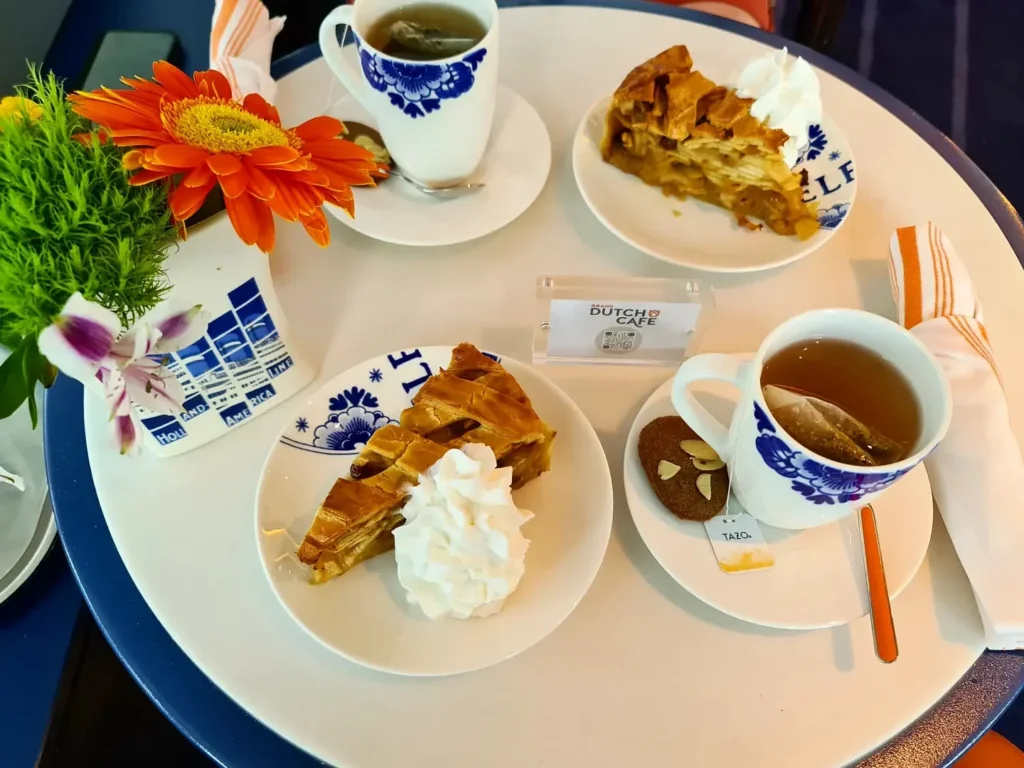 Cruising with Danny and Peter, Holland America Line, Koningsdam, Pacific Ocean, Sea Day | A stunning sunrise over the ocean during a Hawaiian cruise, showcasing the vibrant colors of the sky, a luxury cruise ship on calm waters, guests enjoying marine biology lectures, participating in ukulele lessons, and savoring delicious culinary experiences, embodying relaxation and adventure at sea in the beautiful Hawaiian Islands.