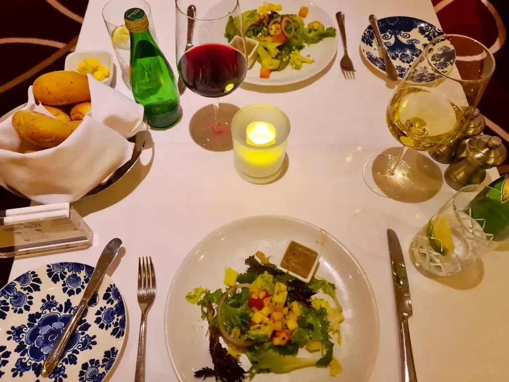 Cruising with Danny and Peter, Holland America Line, Koningsdam, Pacific Ocean, Sea Day | A stunning sunrise over the ocean during a Hawaiian cruise, showcasing the vibrant colors of the sky, a luxury cruise ship on calm waters, guests enjoying marine biology lectures, participating in ukulele lessons, and savoring delicious culinary experiences, embodying relaxation and adventure at sea in the beautiful Hawaiian Islands.