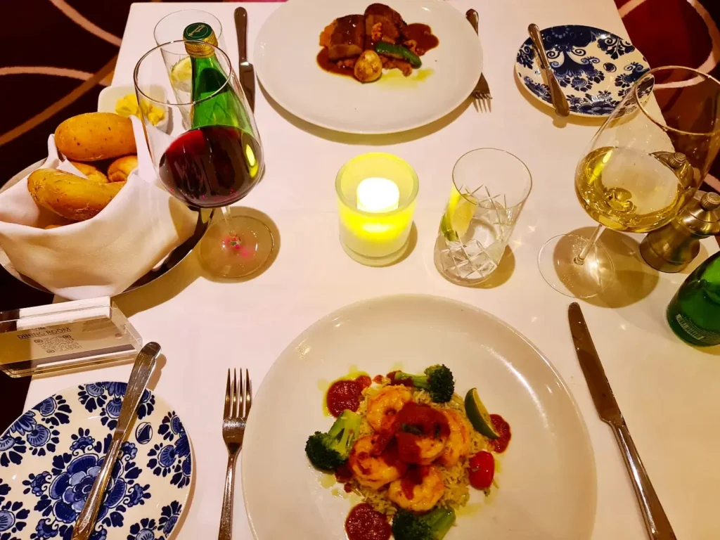 Cruising with Danny and Peter, Holland America Line, Koningsdam, Pacific Ocean, Sea Day | A stunning sunrise over the ocean during a Hawaiian cruise, showcasing the vibrant colors of the sky, a luxury cruise ship on calm waters, guests enjoying marine biology lectures, participating in ukulele lessons, and savoring delicious culinary experiences, embodying relaxation and adventure at sea in the beautiful Hawaiian Islands.