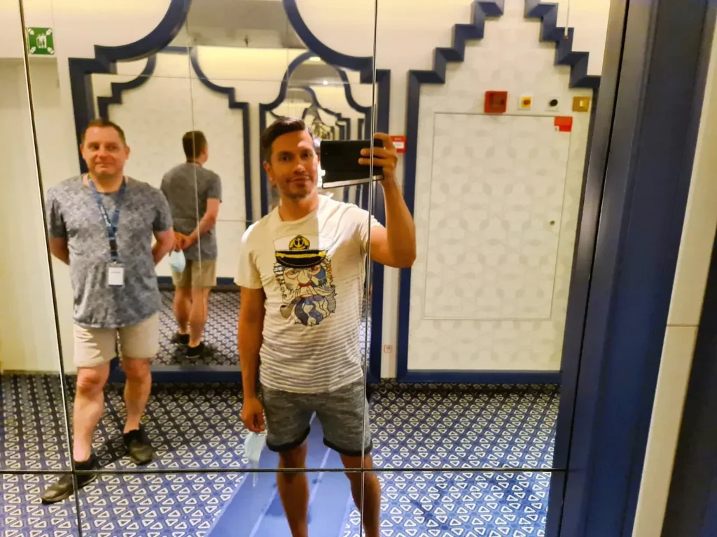 Cruising with Danny and Peter, Holland America Line, Koningsdam, Pacific Ocean, Sea Day | Group of travelers enjoying ukulele lessons on the deck of a cruise ship during an ocean voyage. Vibrant sunset over the sea, showcasing the essence of Hawaiian culture. Participants performing in a live music at sea event, celebrating their ukulele performances together, surrounded by the beauty of the ocean and the warmth of camaraderie.