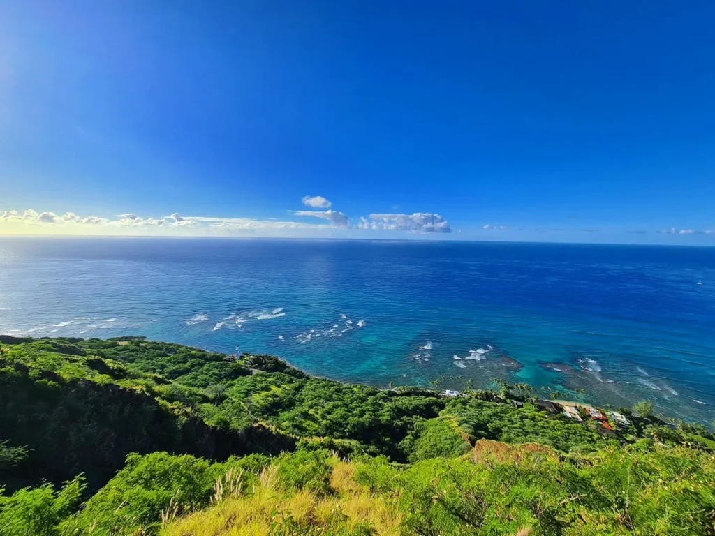 Cruising with Danny and Peter, Holland America Line, Koningsdam, Honolulu, Hawaii, United States | Breathtaking views from the Diamond Head summit during the hike, showcasing scenic views of Honolulu and Waikiki Beach, capturing the essence of volcano hiking in Hawaii, followed by a vibrant scene from Germaine's Luau, highlighting traditional Hawaiian feast, cultural events in Hawaii, and mesmerizing Hawaiian dance performances, all reflecting the rich Polynesian culture and Hawaiian hospitality.
