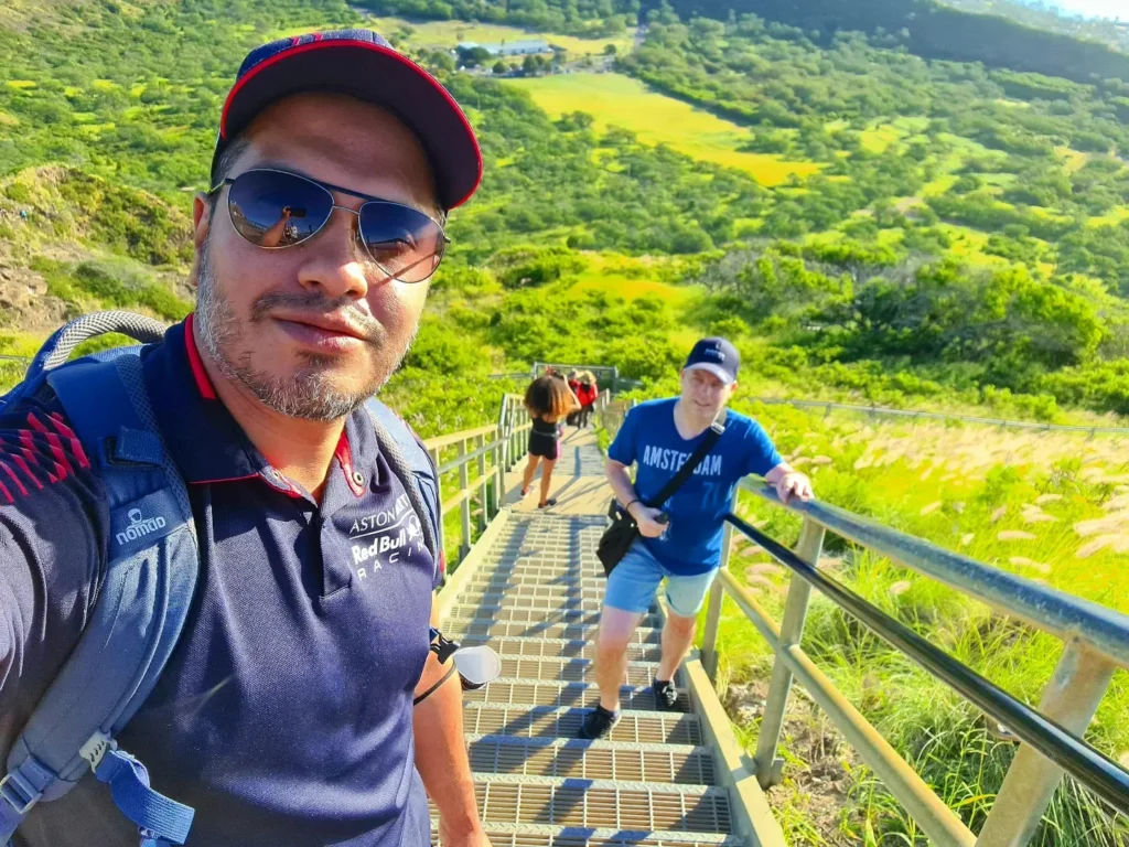 Cruising with Danny and Peter, Holland America Line, Koningsdam, Honolulu, Hawaii, United States | Breathtaking views from the Diamond Head summit during the hike, showcasing scenic views of Honolulu and Waikiki Beach, capturing the essence of volcano hiking in Hawaii, followed by a vibrant scene from Germaine's Luau, highlighting traditional Hawaiian feast, cultural events in Hawaii, and mesmerizing Hawaiian dance performances, all reflecting the rich Polynesian culture and Hawaiian hospitality.