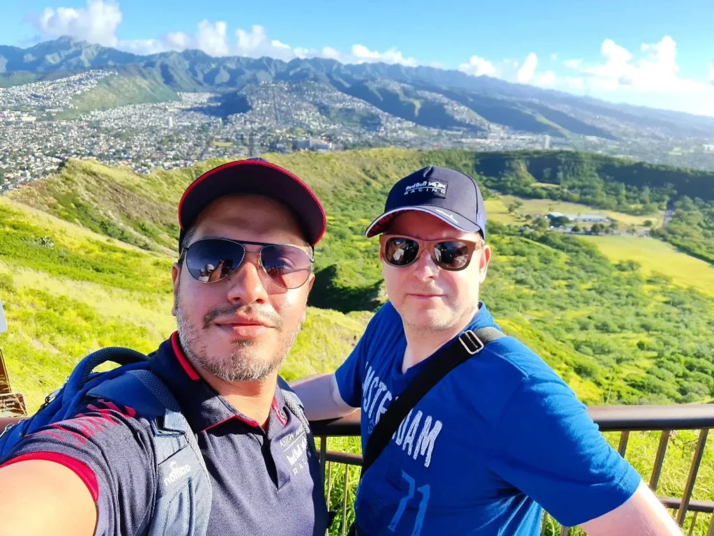 Cruising with Danny and Peter, Holland America Line, Koningsdam, Honolulu, Hawaii, United States | Breathtaking views from the Diamond Head summit during the hike, showcasing scenic views of Honolulu and Waikiki Beach, capturing the essence of volcano hiking in Hawaii, followed by a vibrant scene from Germaine's Luau, highlighting traditional Hawaiian feast, cultural events in Hawaii, and mesmerizing Hawaiian dance performances, all reflecting the rich Polynesian culture and Hawaiian hospitality.