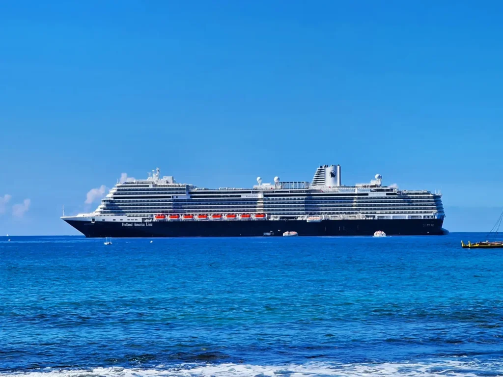 Cruising with Danny and Peter, Holland America Line, Koningsdam, Kona, Hawaii, United-States | A vibrant scene showcasing the beauty of Kona Hawaii, featuring secluded beaches with soft sand and crystal-clear waters, colorful storefronts along the bustling streets, and breathtaking scenic views of the Kona coast during sunset. The image captures the essence of Exploring Kona's Island Charm, highlighting local culture with hula dancers and delicious Hawaiian cuisine served at a beachfront restaurant.