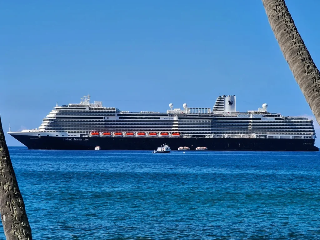 Cruising with Danny and Peter, Holland America Line, Koningsdam, Kona, Hawaii, United-States | A vibrant scene showcasing the beauty of Kona Hawaii, featuring secluded beaches with soft sand and crystal-clear waters, colorful storefronts along the bustling streets, and breathtaking scenic views of the Kona coast during sunset. The image captures the essence of Exploring Kona's Island Charm, highlighting local culture with hula dancers and delicious Hawaiian cuisine served at a beachfront restaurant.