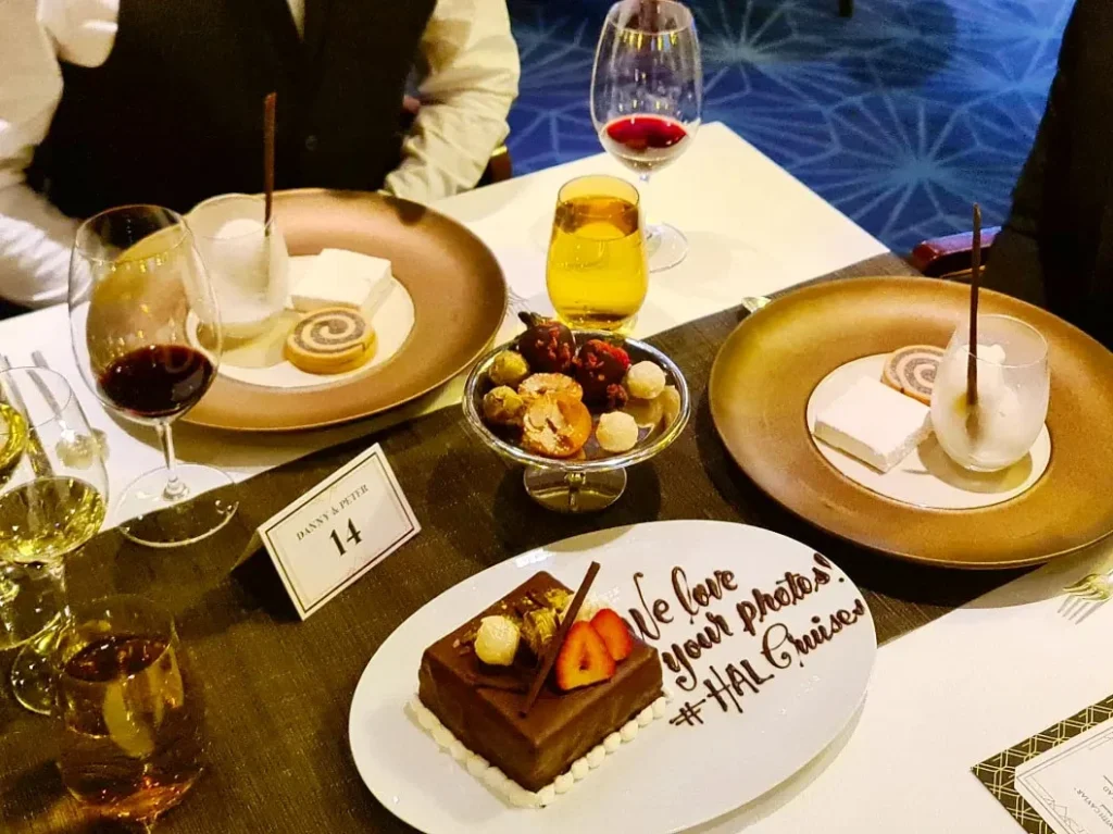 Cruising with Danny and Peter, Holland America Line, Koningsdam, Sea Day | Guests enjoying the Holland America Gala Night on the Koningsdam, featuring elegant dining setups, gourmet cuisine such as halibut with lobster and beef tenderloin, and lively conversations over fine wine, capturing the essence of a luxury cruise experience.