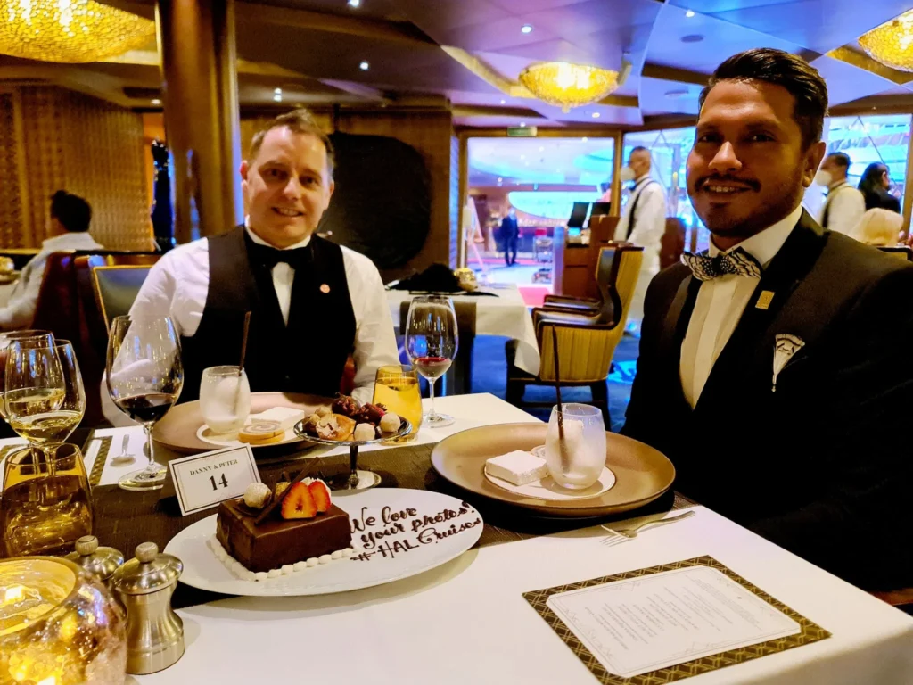 Cruising with Danny and Peter, Holland America Line, Koningsdam, Sea Day | Guests enjoying the Holland America Gala Night on the Koningsdam, featuring elegant dining setups, gourmet cuisine such as halibut with lobster and beef tenderloin, and lively conversations over fine wine, capturing the essence of a luxury cruise experience.