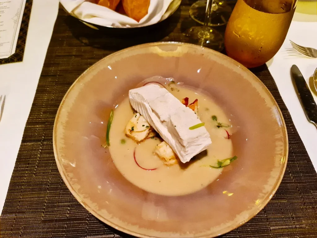 Cruising with Danny and Peter, Holland America Line, Koningsdam, Sea Day | Guests enjoying the Holland America Gala Night on the Koningsdam, featuring elegant dining setups, gourmet cuisine such as halibut with lobster and beef tenderloin, and lively conversations over fine wine, capturing the essence of a luxury cruise experience.