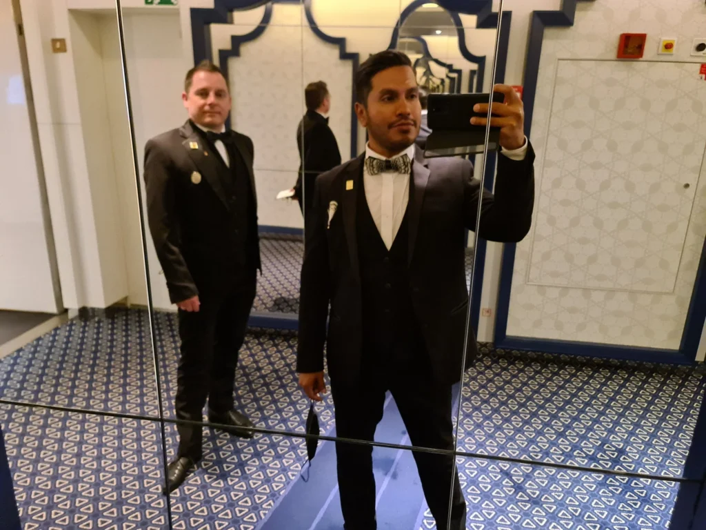 Cruising with Danny and Peter, Holland America Line, Koningsdam, Sea Day | Guests enjoying the Holland America Gala Night on the Koningsdam, featuring elegant dining setups, gourmet cuisine such as halibut with lobster and beef tenderloin, and lively conversations over fine wine, capturing the essence of a luxury cruise experience.