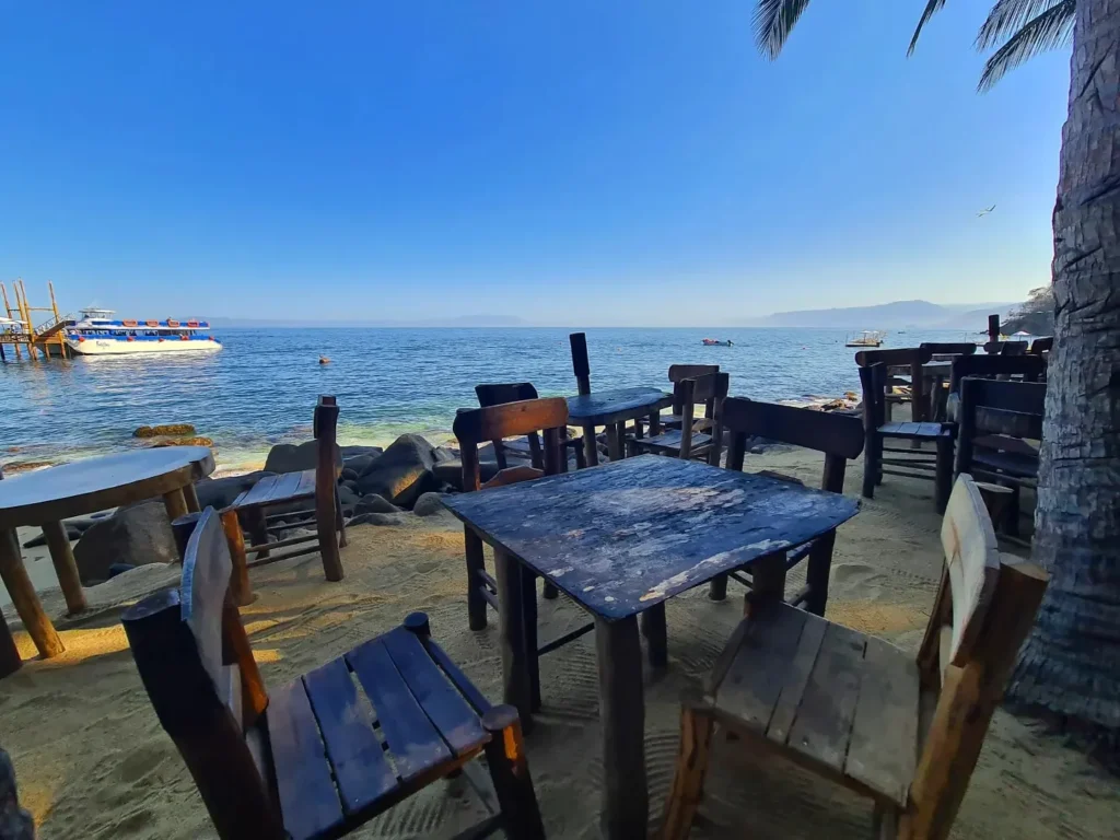 Cruising with Danny and Peter, Holland America Line, Koningsdam, Puerto Vallarta, Mexico | Las Caletas Beach in Puerto Vallarta featuring serene sandy shores, lush tropical greenery, and guests enjoying a relaxing beach day. The scene captures the essence of a secluded beach getaway with clear blue waters, vibrant Mexican cuisine, and the tranquil atmosphere of this hidden gem.