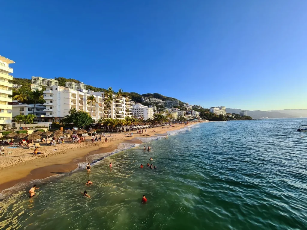 Cruising with Danny and Peter, Holland America Line, Koningsdam, Puerto Vallarta, Mexico | Las Caletas Beach in Puerto Vallarta featuring serene sandy shores, lush tropical greenery, and guests enjoying a relaxing beach day. The scene captures the essence of a secluded beach getaway with clear blue waters, vibrant Mexican cuisine, and the tranquil atmosphere of this hidden gem.