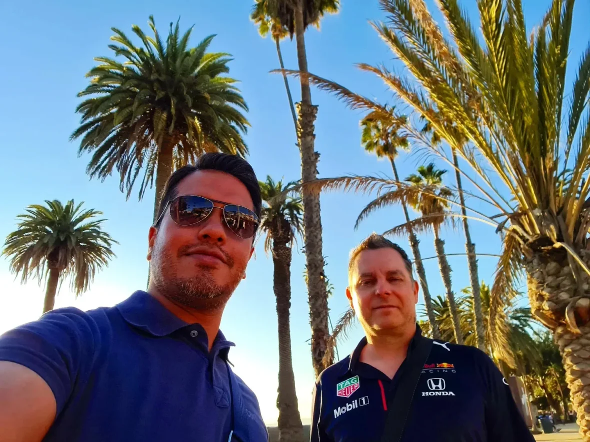 Cruising with Danny and Peter, Holland America Line, Koningsdam, San Diego, Los Angeles, California, United States | A stunning view of the Pacific coastline during a sunset sojourn from San Diego to Santa Monica, featuring vibrant hues of orange and pink in the sky, palm trees lining the oceanfront promenade, and the iconic Santa Monica Pier in the distance, capturing the essence of a scenic beach getaway and the California golden hour.