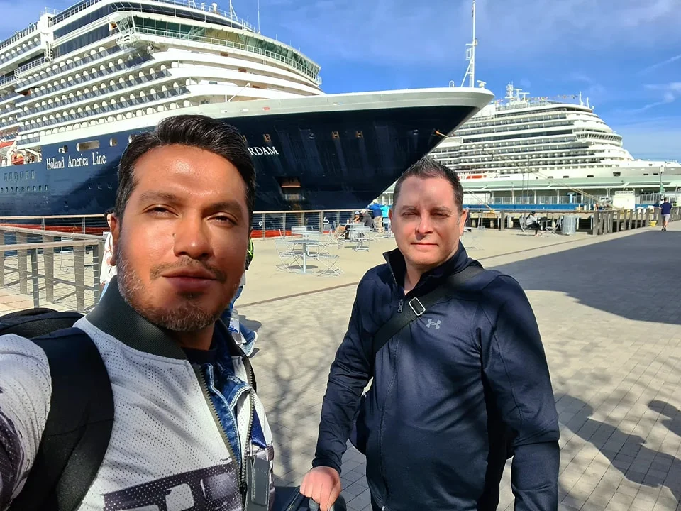 Cruising with Danny and Peter, Holland America Line, Koningsdam, San Diego, Los Angeles, California, United States | A stunning view of the Pacific coastline during a sunset sojourn from San Diego to Santa Monica, featuring vibrant hues of orange and pink in the sky, palm trees lining the oceanfront promenade, and the iconic Santa Monica Pier in the distance, capturing the essence of a scenic beach getaway and the California golden hour.