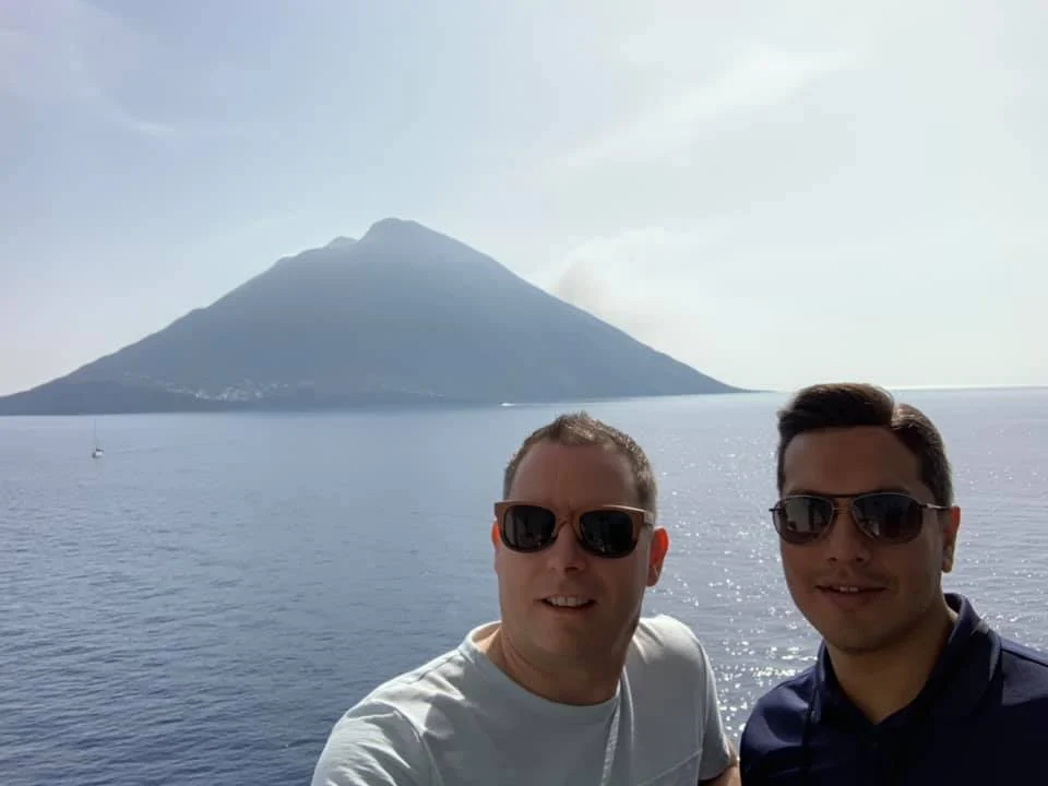 Cruising with Danny and Peter, Holland America Line, Koningsdam, Sea Day | Scenic view from a Mediterranean Cruise ship with sunbathers enjoying a Relaxing Day at Sea and the Stromboli Volcano in the background