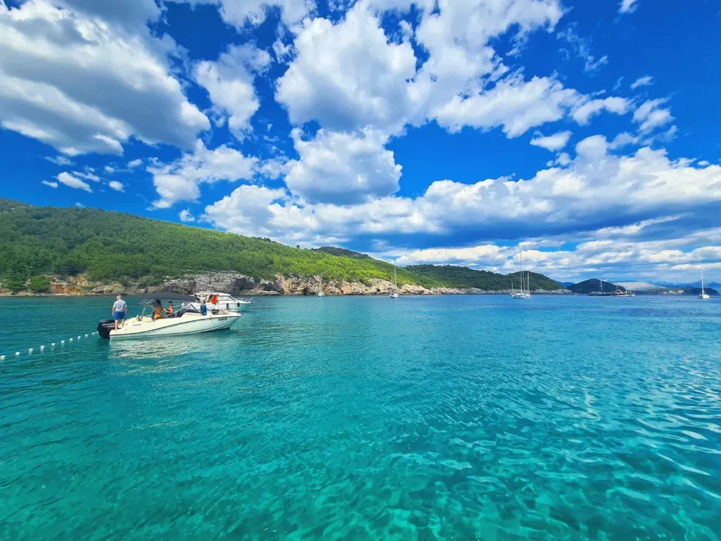 Cruising with Danny and Peter, Holland America Line, Oosterdam, Dubrovnik, Croatia | A stunning view of Dubrovnik's iconic city walls and terracotta rooftops during a private boat tour on the Adriatic Sea, showcasing the serene coastline and picturesque landscapes, highlighting the beauty of a Dubrovnik sailing trip.