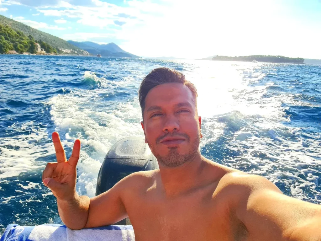 Cruising with Danny and Peter, Holland America Line, Oosterdam, Dubrovnik, Croatia | A stunning view of Dubrovnik's iconic city walls and terracotta rooftops during a private boat tour on the Adriatic Sea, showcasing the serene coastline and picturesque landscapes, highlighting the beauty of a Dubrovnik sailing trip.v