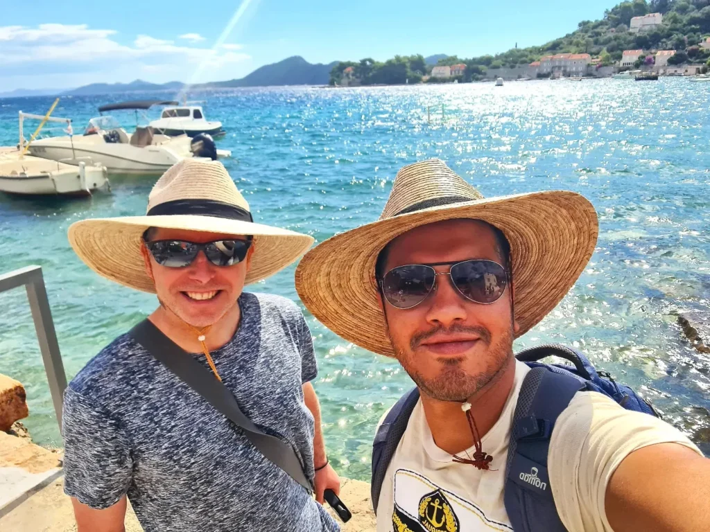 Cruising with Danny and Peter, Holland America Line, Oosterdam, Dubrovnik, Croatia | A stunning view of Dubrovnik's iconic city walls and terracotta rooftops during a private boat tour on the Adriatic Sea, showcasing the serene coastline and picturesque landscapes, highlighting the beauty of a Dubrovnik sailing trip.