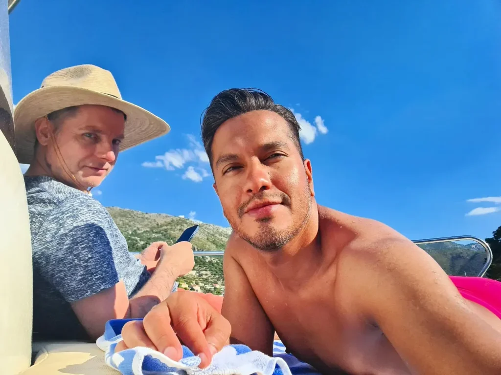 Cruising with Danny and Peter, Holland America Line, Oosterdam, Dubrovnik, Croatia | A stunning view of Dubrovnik's iconic city walls and terracotta rooftops during a private boat tour on the Adriatic Sea, showcasing the serene coastline and picturesque landscapes, highlighting the beauty of a Dubrovnik sailing trip.