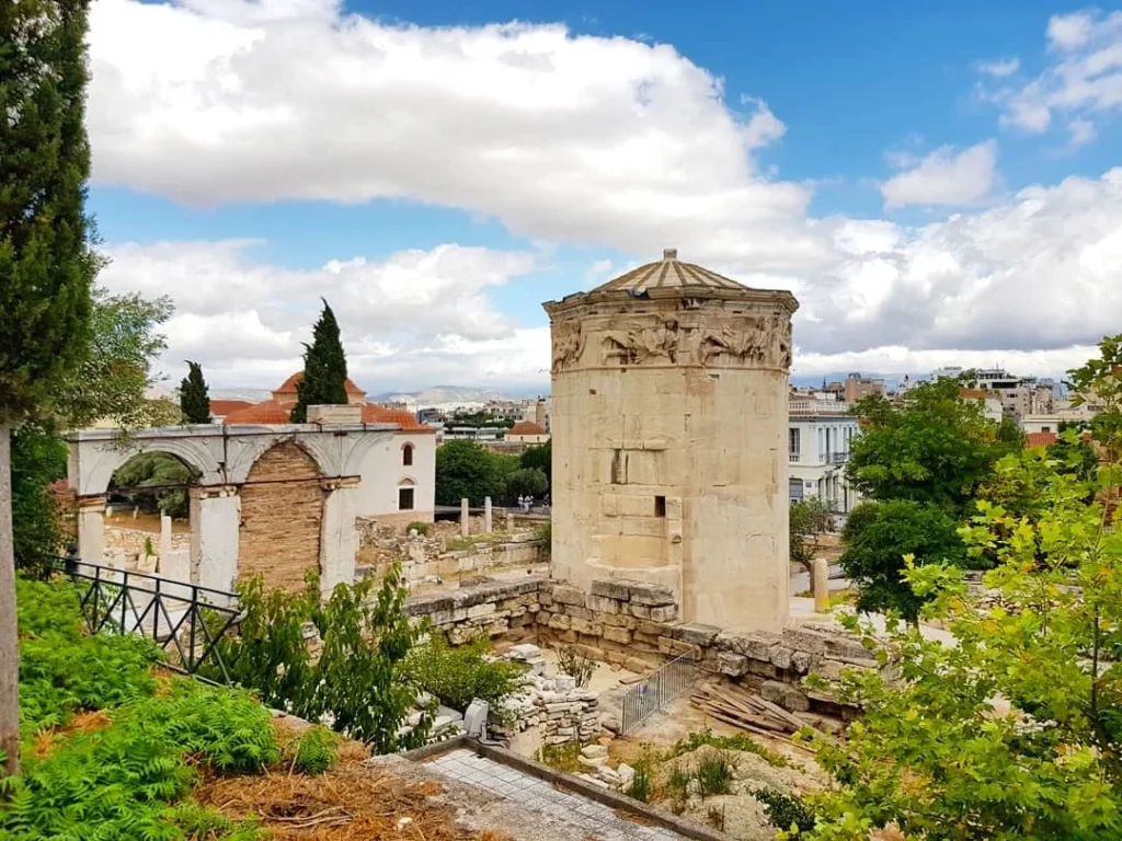 Cruising with Danny and Peter, Holland America Line, Koningsdam, Piraeus, Athens, Greece | A vibrant street art mural in Athens, showcasing the city's artistic spirit, with the Acropolis in the background; a local café offering panoramic views, perfect for an Athens Instagram Tour; hidden gems of Athens, including narrow alleys and quaint courtyards filled with history and charm.