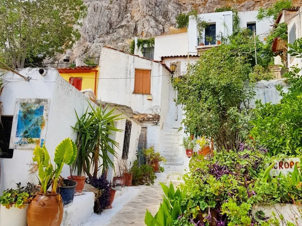 Cruising with Danny and Peter, Holland America Line, Koningsdam, Piraeus, Athens, Greece | A vibrant street art mural in Athens, showcasing the city's artistic spirit, with the Acropolis in the background; a local café offering panoramic views, perfect for an Athens Instagram Tour; hidden gems of Athens, including narrow alleys and quaint courtyards filled with history and charm.