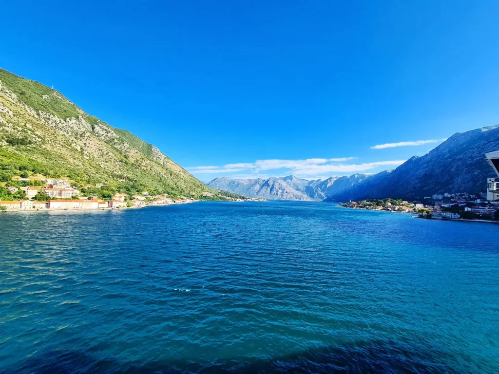 Cruising with Danny and Peter, Holland America Line, Oosterdam, Kotor, Montenegro | Stunning view of Kotor Bay, showcasing the charming villages and scenic beaches of Montenegro. The image features the medieval architecture of Budva Old Town, the crystal-clear waters of Jaz Beach, and the picturesque landscapes of Brajići, highlighting the cultural heritage and natural beauty of the Adriatic Coast.