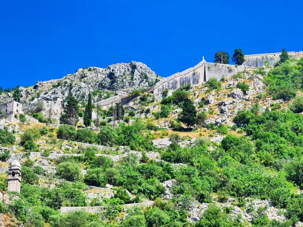 Cruising with Danny and Peter, Holland America Line, Oosterdam, Kotor, Montenegro | Stunning view of Kotor Bay, showcasing the charming villages and scenic beaches of Montenegro. The image features the medieval architecture of Budva Old Town, the crystal-clear waters of Jaz Beach, and the picturesque landscapes of Brajići, highlighting the cultural heritage and natural beauty of the Adriatic Coast.