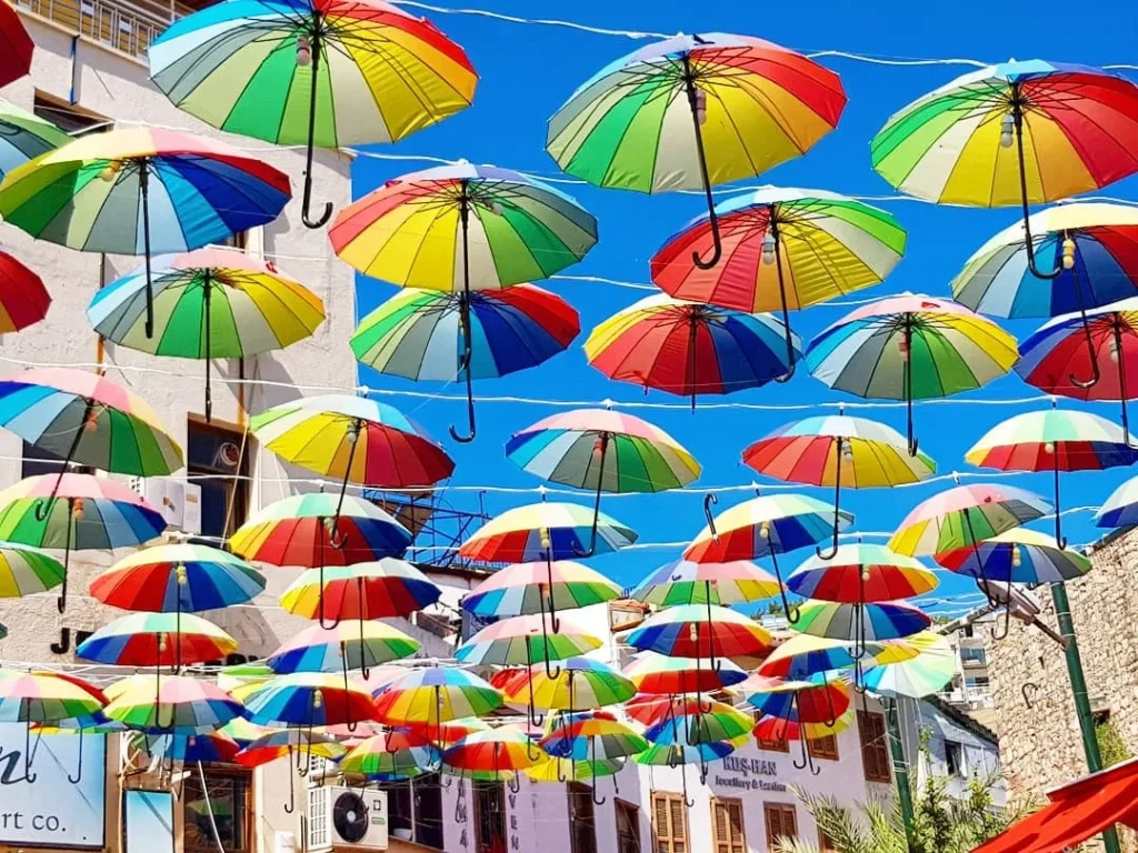 Cruising with Danny and Peter, Holland America Line, Koningsdam, Kusadasi, Ephesus, Turkey | A picturesque view of Kuşadası Beach showcasing soft golden sands and crystal-clear Aegean Sea waters, vibrant local markets filled with traditional Turkish crafts, and visitors savoring authentic Turkish cuisine at a charming café, highlighting the cultural exploration and seaside relaxation of a perfect Kuşadası Beach Day on the Turkish Riviera.