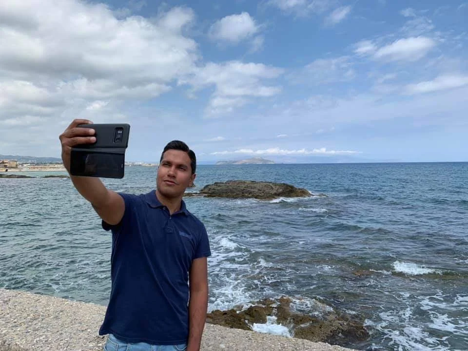 Cruising with Danny and Peter, Holland America Line, Koningsdam, Souda, Chania, Greece | Scenic view of Souda Port with fishing boats and distant mountains, charming streets of Chania with Venetian architecture, and vibrant Crete local markets during a Greek Island Adventure.