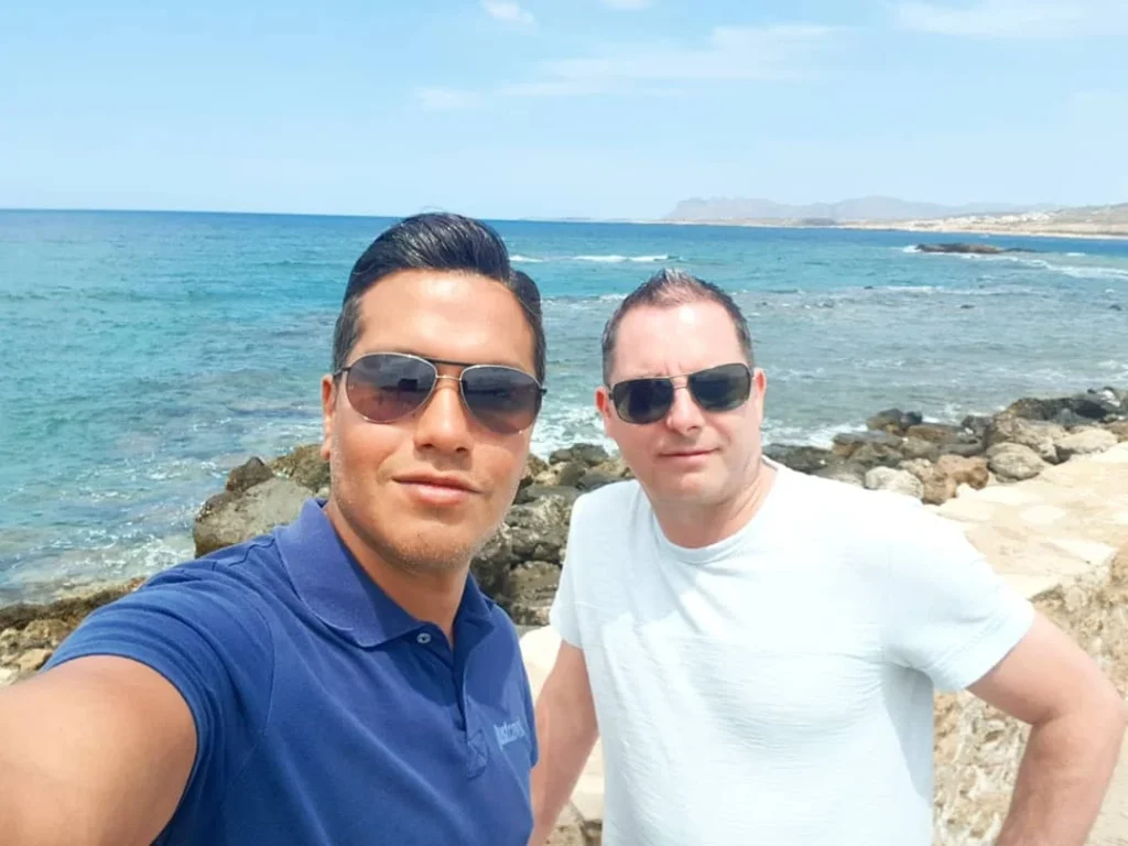 Cruising with Danny and Peter, Holland America Line, Koningsdam, Souda, Chania, Greece | Scenic view of Souda Port with fishing boats and distant mountains, charming streets of Chania with Venetian architecture, and vibrant Crete local markets during a Greek Island Adventure.
