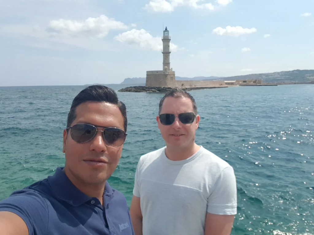 Cruising with Danny and Peter, Holland America Line, Koningsdam, Souda, Chania, Greece | Scenic view of Souda Port with fishing boats and distant mountains, charming streets of Chania with Venetian architecture, and vibrant Crete local markets during a Greek Island Adventure.
