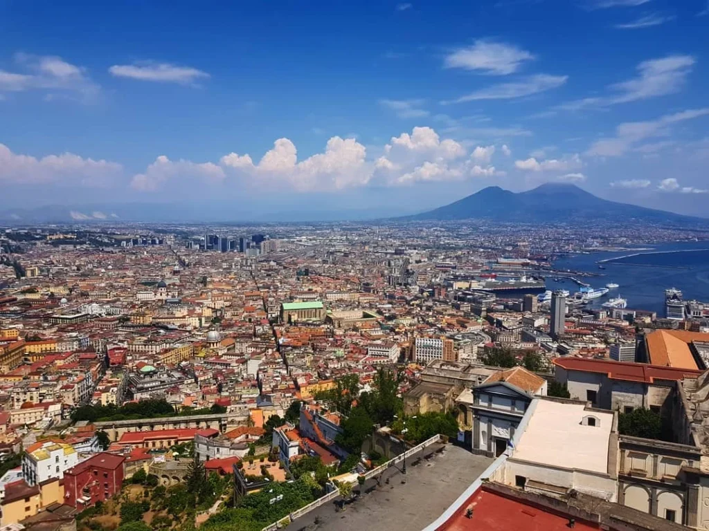 Cruising with Danny and Peter, Holland America Line, Koningsdam, Naples, Pompeii, Amalfi, Italy | View of the Stromboli volcanic eruption at night from the Koningsdam deck during an Italy volcano cruise experience, showcasing the fiery bursts illuminating the sky, with Naples bay scenery in the background and a group of travelers admiring the spectacle.
