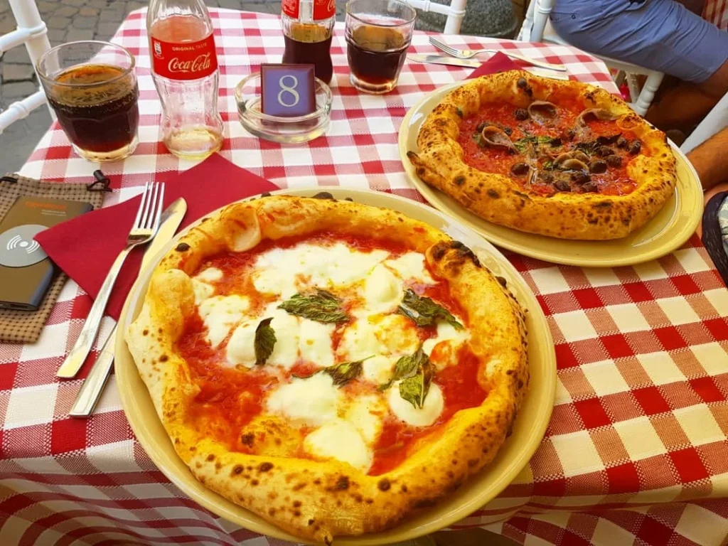 Cruising with Danny and Peter, Holland America Line, Koningsdam, Naples, Pompeii, Amalfi, Italy | View of the Stromboli volcanic eruption at night from the Koningsdam deck during an Italy volcano cruise experience, showcasing the fiery bursts illuminating the sky, with Naples bay scenery in the background and a group of travelers admiring the spectacle.