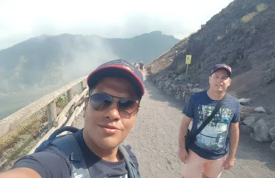 Cruising with Danny and Peter, Holland America Line, Koningsdam, Naples, Pompeii, Amalfi, Italy | View of the Stromboli volcanic eruption at night from the Koningsdam deck during an Italy volcano cruise experience, showcasing the fiery bursts illuminating the sky, with Naples bay scenery in the background and a group of travelers admiring the spectacle.