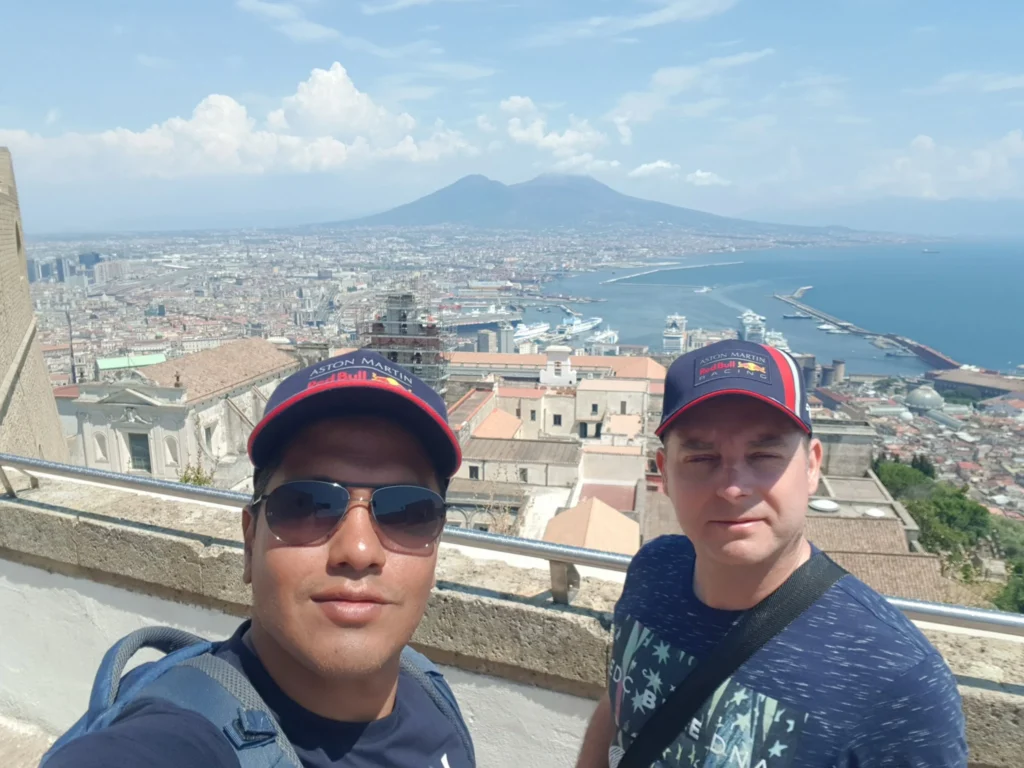 Cruising with Danny and Peter, Holland America Line, Koningsdam, Naples, Pompeii, Amalfi, Italy | View of the Stromboli volcanic eruption at night from the Koningsdam deck during an Italy volcano cruise experience, showcasing the fiery bursts illuminating the sky, with Naples bay scenery in the background and a group of travelers admiring the spectacle.