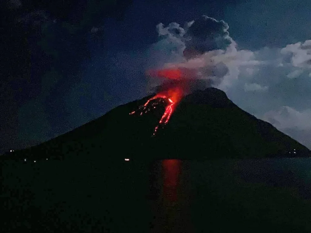 Cruising with Danny and Peter, Holland America Line, Koningsdam, Naples, Pompeii, Amalfi, Italy | View of the Stromboli volcanic eruption at night from the Koningsdam deck during an Italy volcano cruise experience, showcasing the fiery bursts illuminating the sky, with Naples bay scenery in the background and a group of travelers admiring the spectacle.